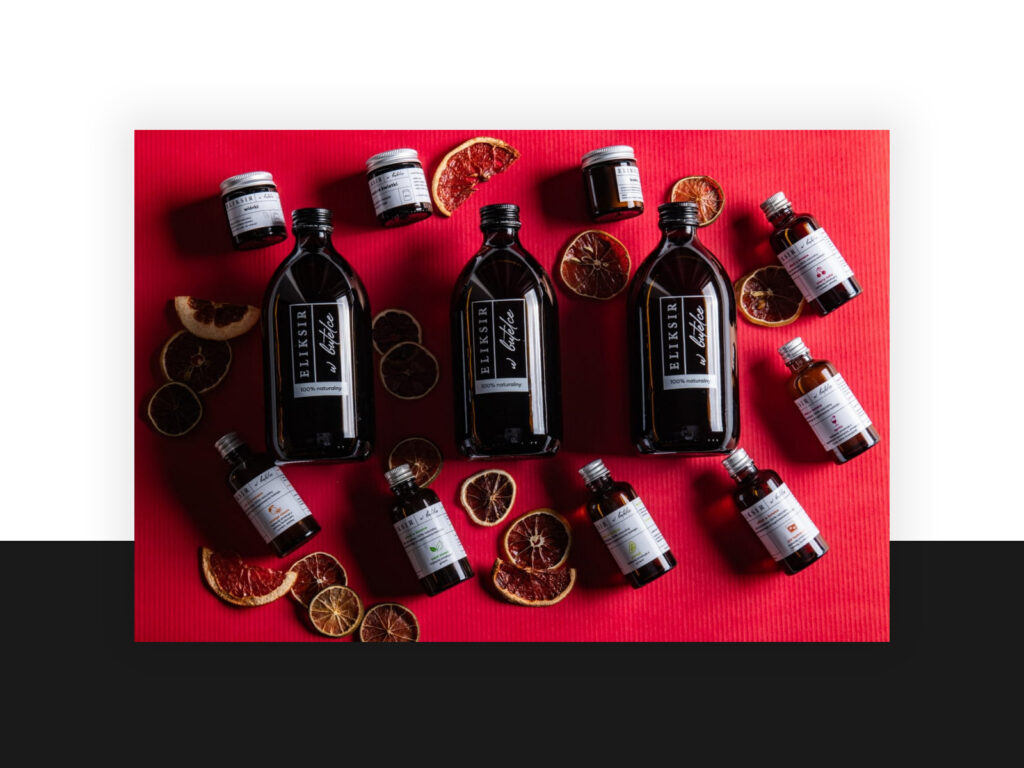 Eliksir w butelce bottles and jars with dried citrus on a red background