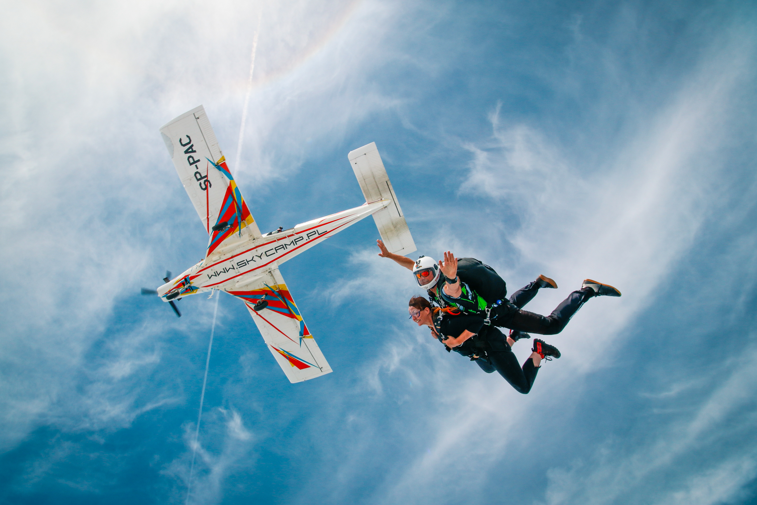Skydivers falling away from the plane among clouds