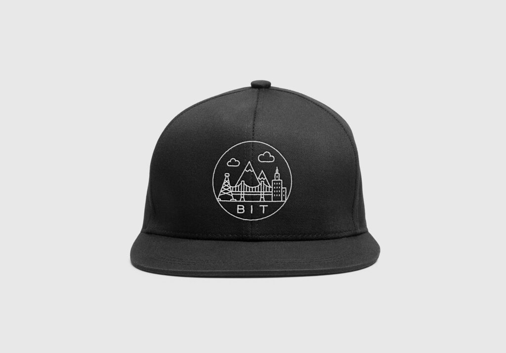 Black cap with the round Base Inspired Travels badge, front view