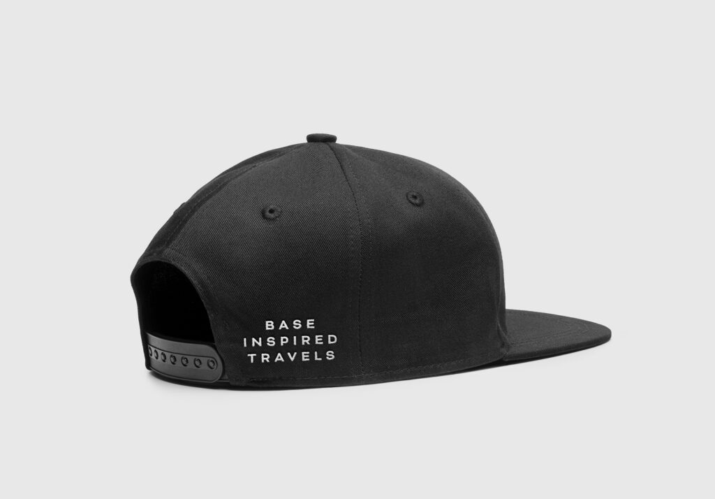 Black cap with Base Inspired Travels lettering, side view