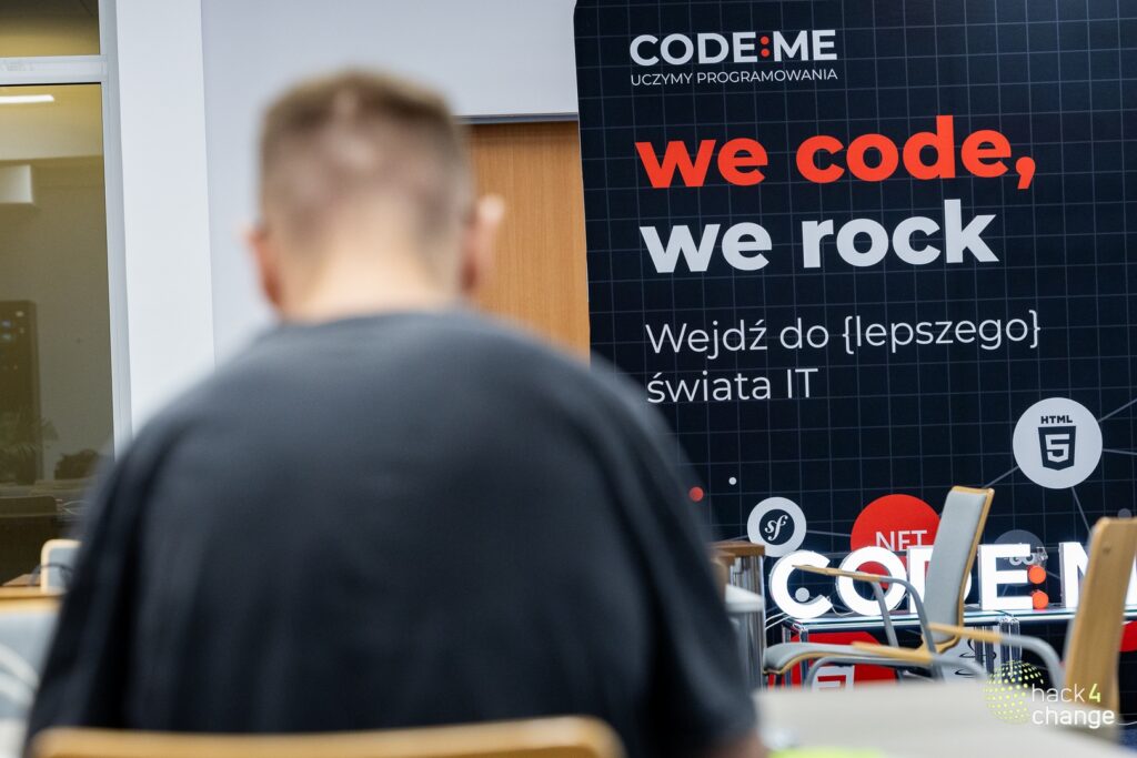Participant in front of a CODE:ME "we code, we rock" banner
