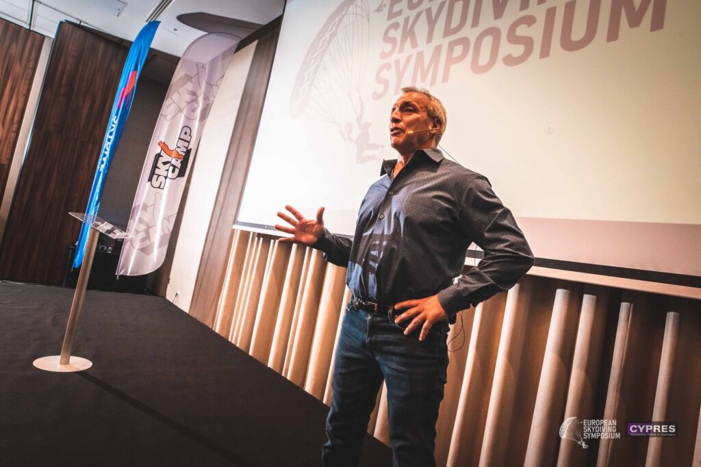 Speaker gesturing on the European Skydiving Symposium stage