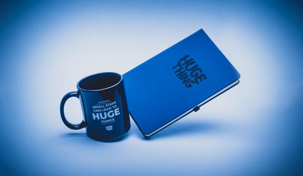Huge Thing mug and notebook on a blue background