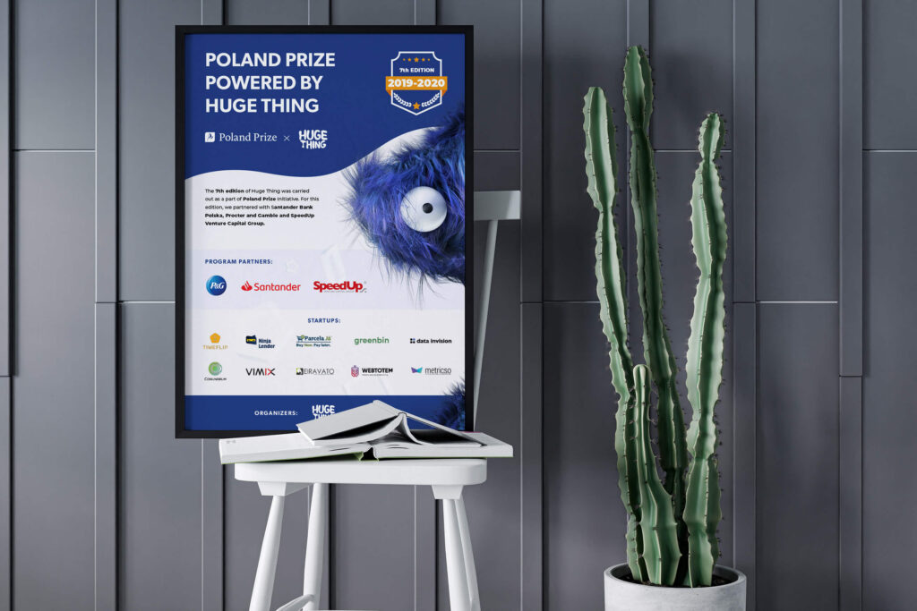 "Poland Prize powered by Huge Thing" poster on a chair next to a cactus
