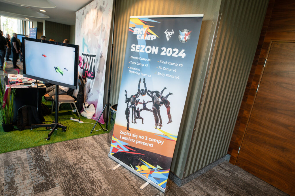 Sky Camp "Sezon 2024" roll-up banner at an indoor event