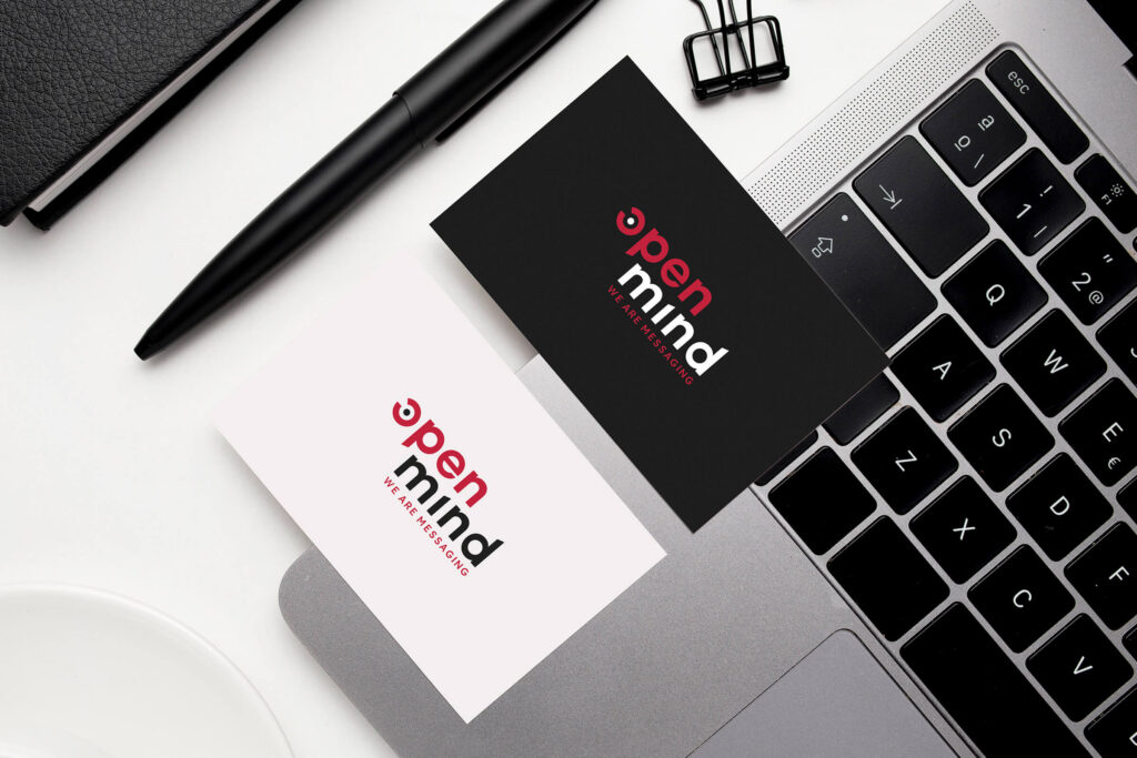 Openmind business cards on a desk next to a laptop