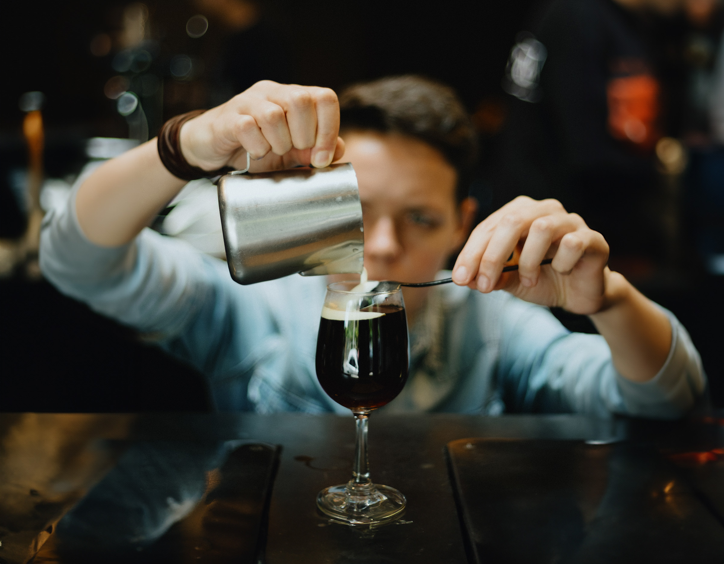 Barista pouring a coffee drink into a wine glass
