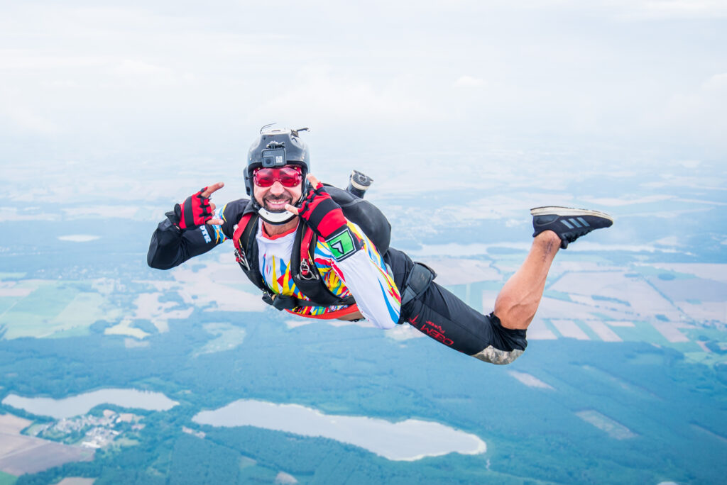 Skydiver in free fall over fields and lakes