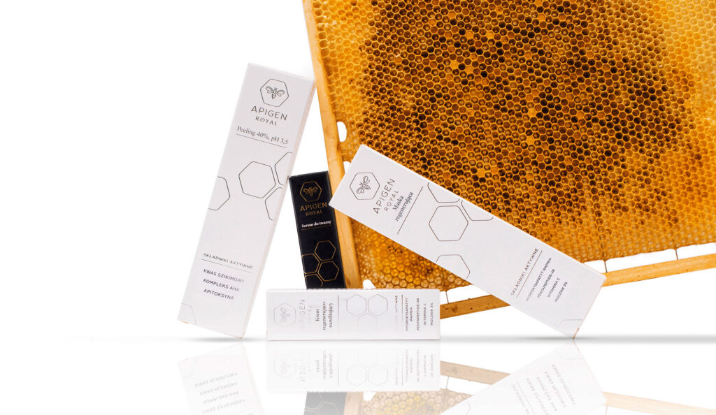 Apigen Royal cosmetic tubes and boxes next to a honeycomb frame