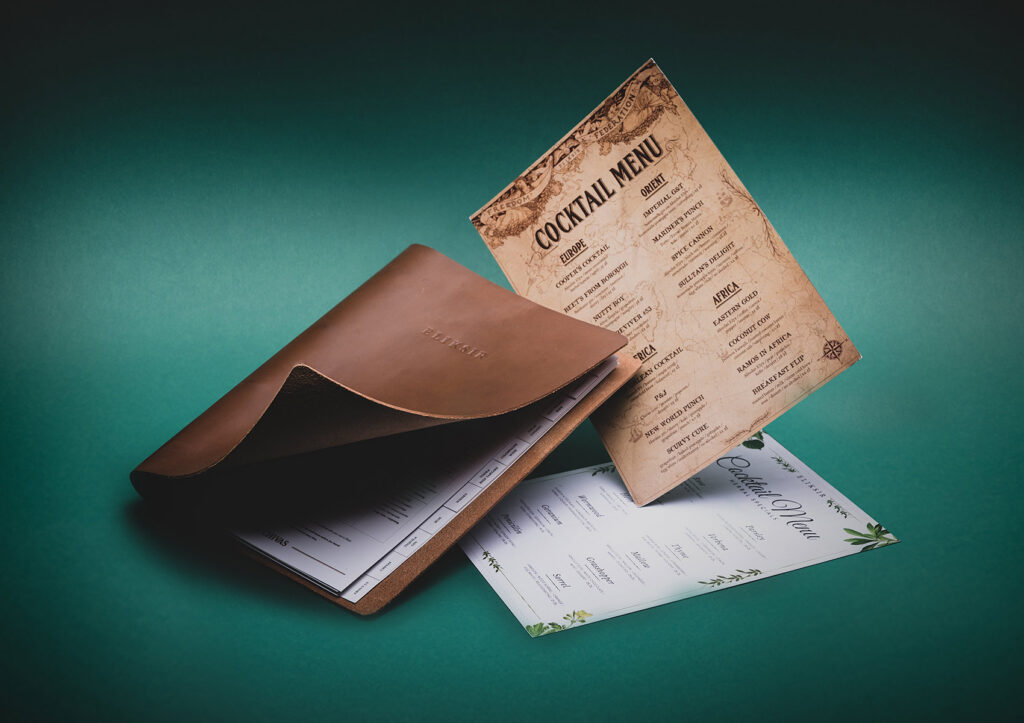 Eliksir cocktail menus in a leather cover on a teal background