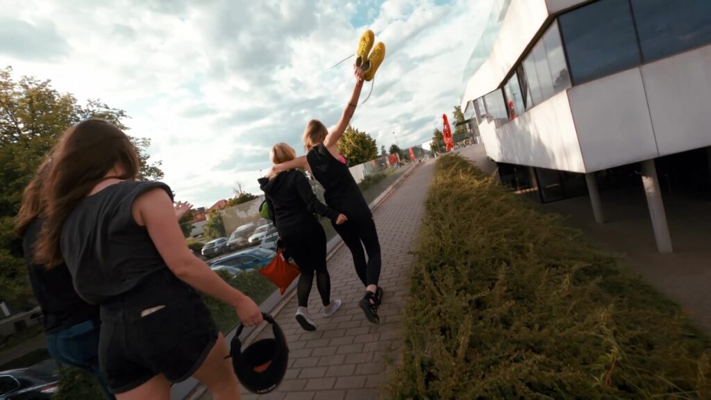 Group walking towards the Flyspot building, one person raising a hand