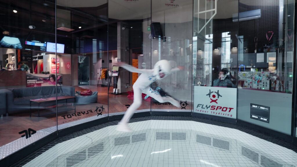 Flyer in a white suit inside the Flyspot wind tunnel