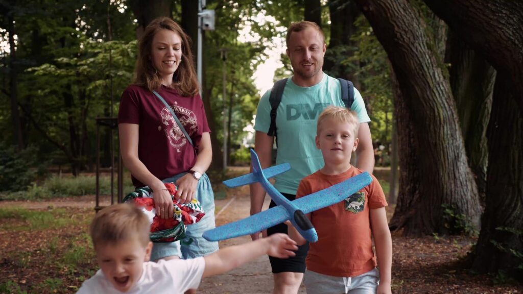 Family with a toy plane in a park, still from a Flyspot ad