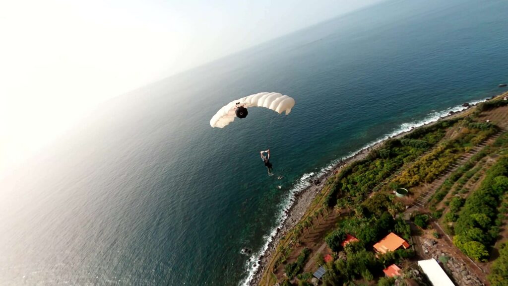 BASE jumper under canopy over the coast of Madeira