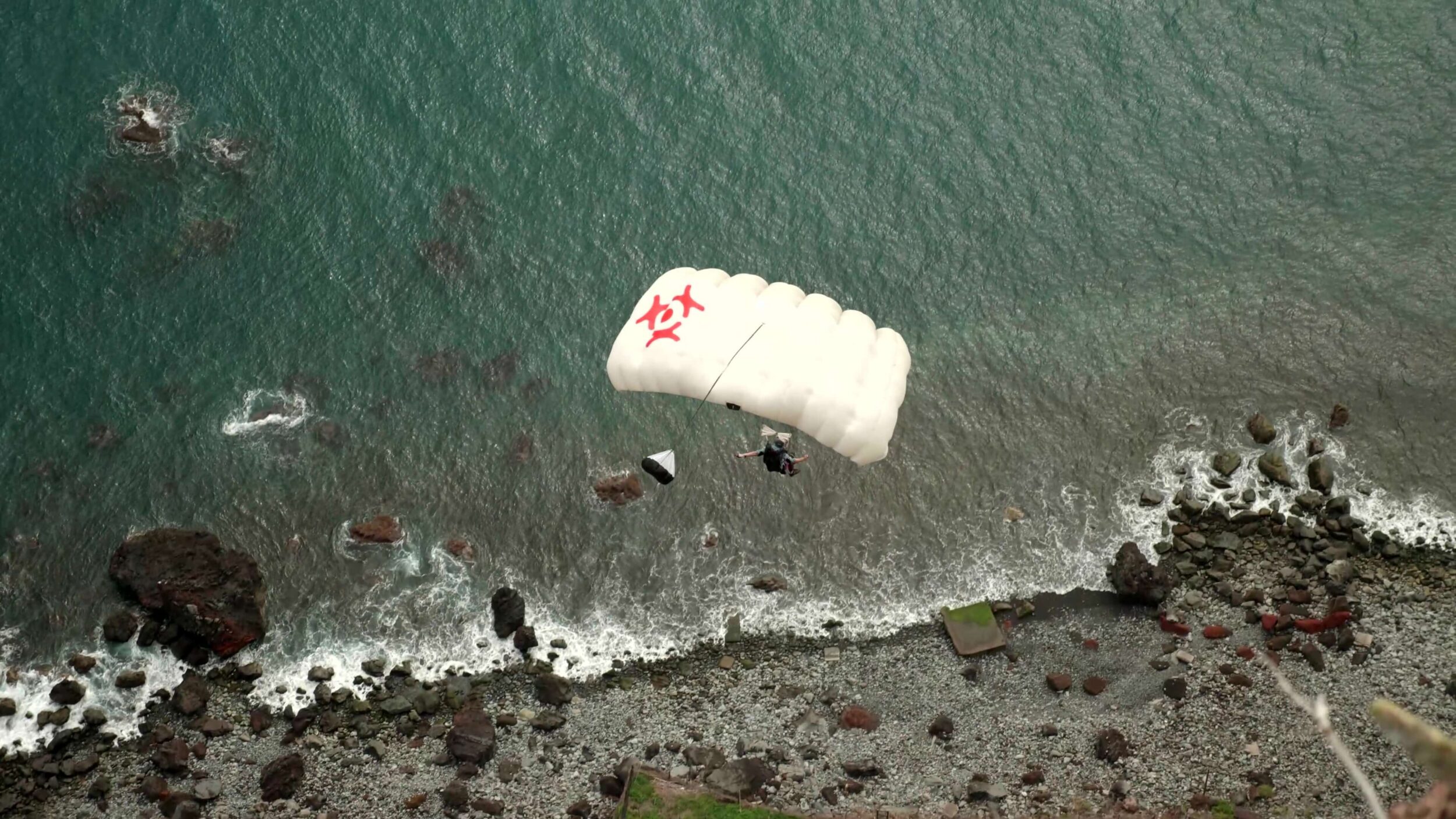Parachute canopy above the sea near a rocky shore, Madeira