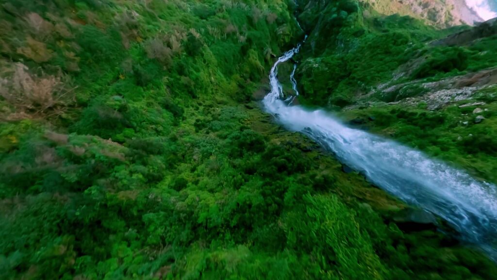 River running through a lush green gorge, seen from above, Madeira