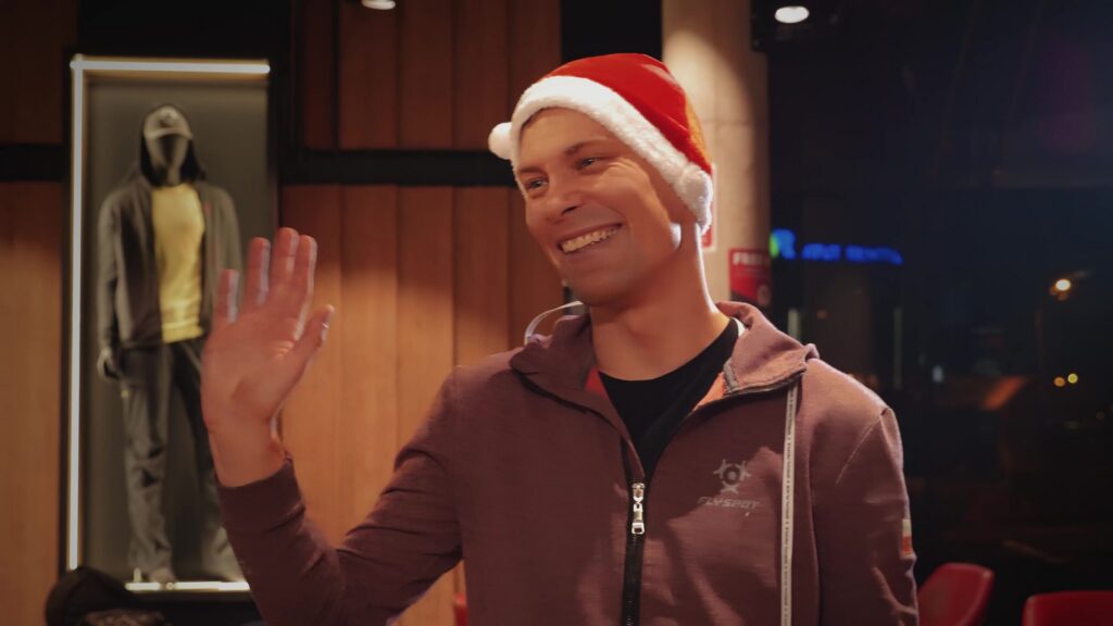 Smiling man in a Santa hat waving in the Flyspot lobby