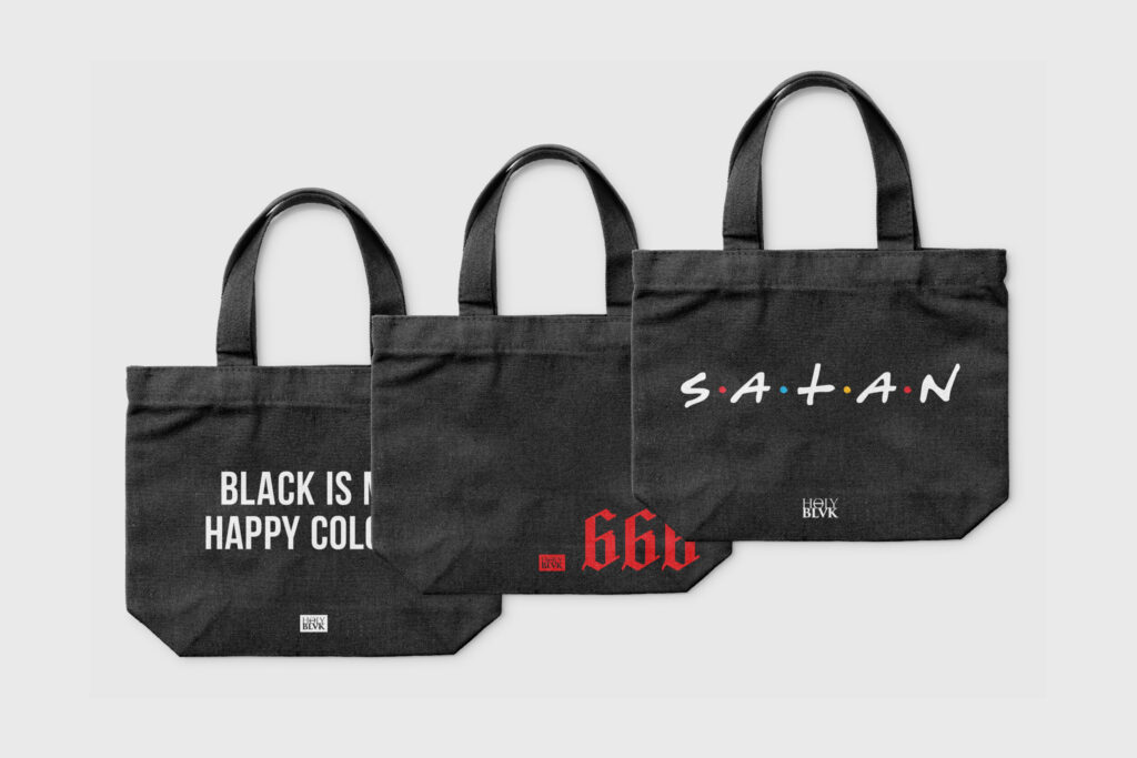 Three black Holy Blvk tote bags with text prints