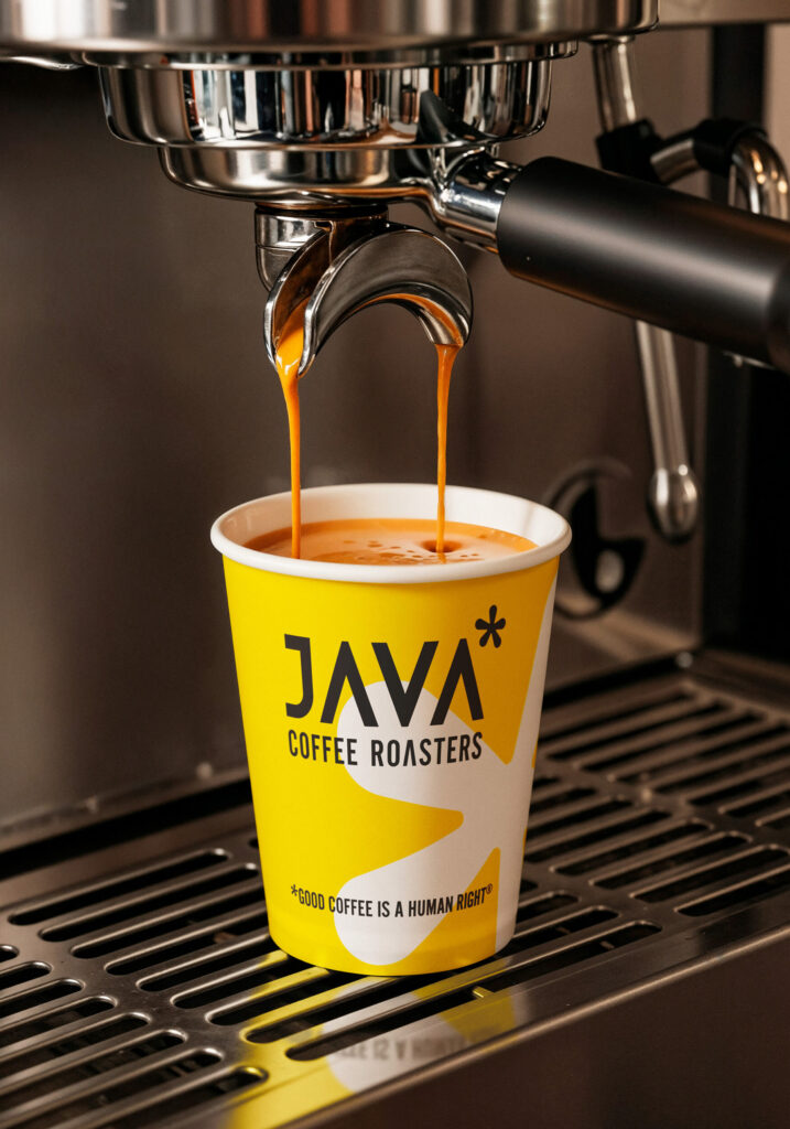JAVA Coffee Roasters paper cup under an espresso machine